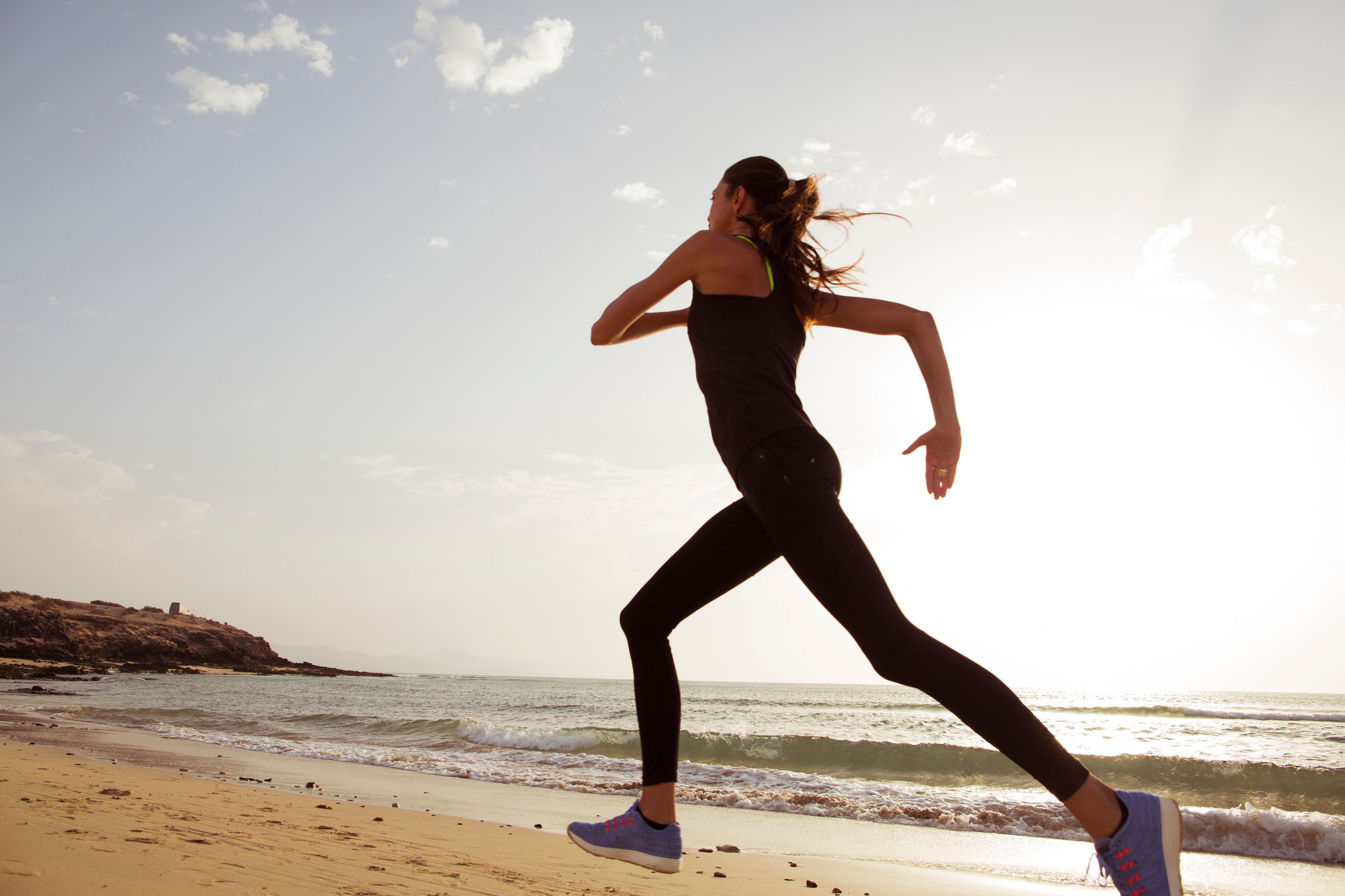 Young sport woman running in the morning on the beach.